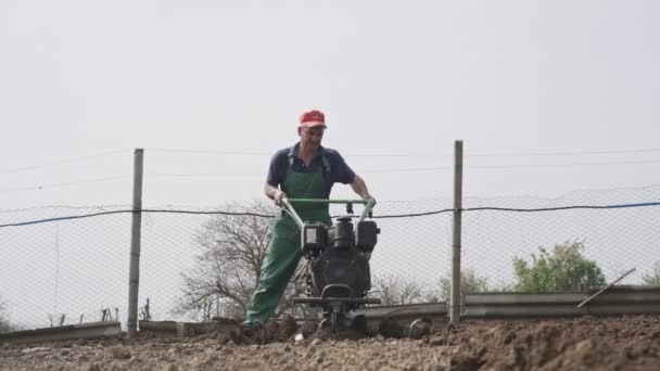 Ember szántás a földet a kertben az ég hátterében — Stock videók