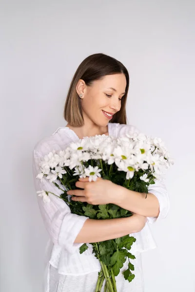 Bellezza donna delicata gode di un bouquet di fiori bianchi — Foto Stock