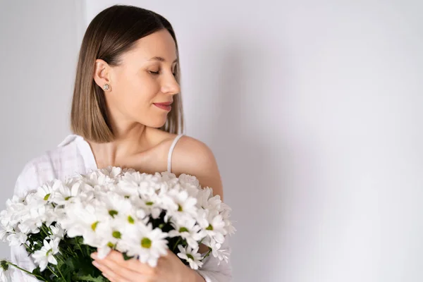 Bellezza donna delicata gode di un bouquet di fiori bianchi — Foto Stock
