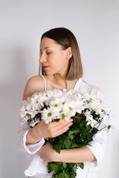 Beleza mulher delicada goza de um buquê de flores brancas — Fotografia de Stock