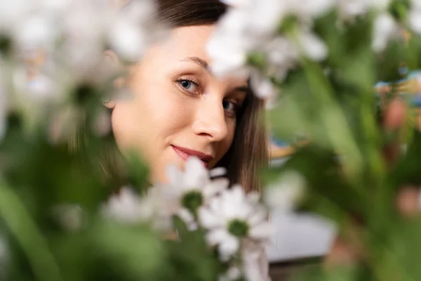 笑顔の女性は新鮮な花を見て — ストック写真