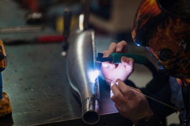 Modern bir atölyede motosiklet tamir eden adam.