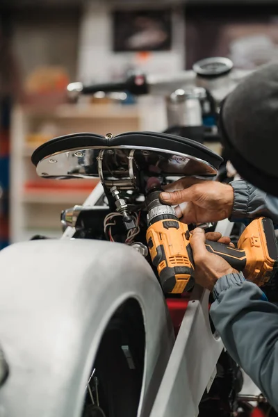Hombre fijando una motocicleta en un taller moderno — Foto de Stock