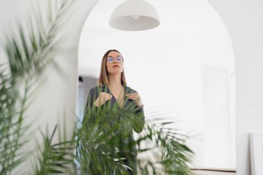 Güzel kadın aynadaki yansımasına bakıyor.