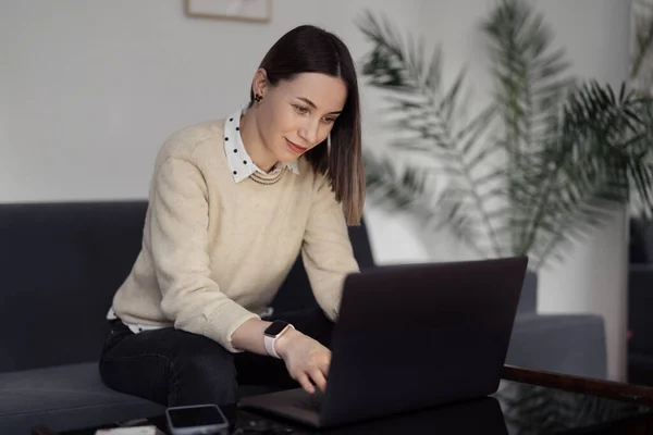 Vrouw met laptop thuis in de woonkamer — Stockfoto