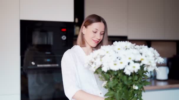 Mooie vrouw zetten verse witte bloemen in een vaas — Stockvideo