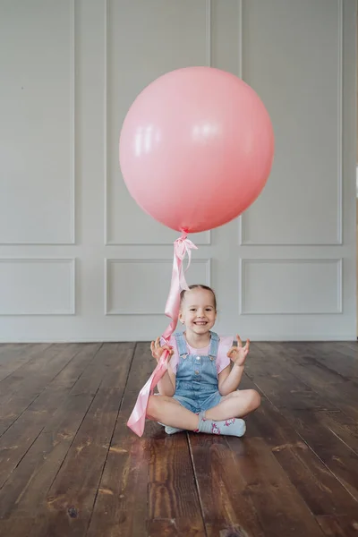 Ребенок играет с розовым шариком и копирует пространство — стоковое фото
