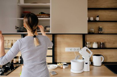 Kadın eve gidip mutfak dükkanından bir şeyler alıyor.