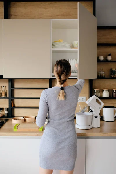Жінка вдома бере щось з кухонного магазину — стокове фото