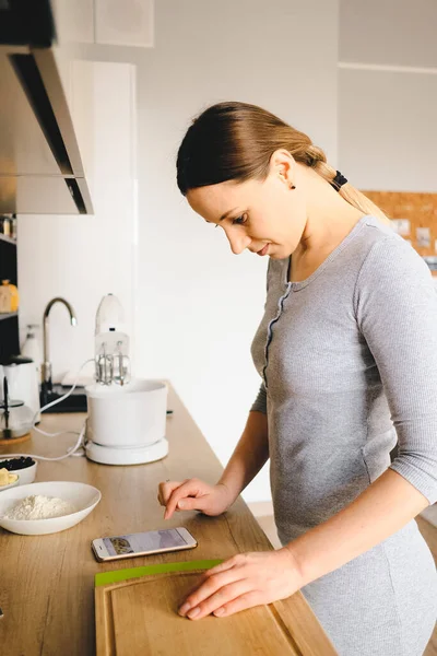 Vrouw kijkt naar het recept aan de telefoon — Stockfoto