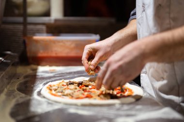 Erkek aşçı elleri pizzacı mutfağında pizza yapıyor.