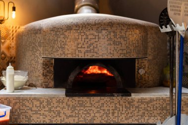 Pizza fırını alevler içinde pizza pişirmeye hazırlanıyor.
