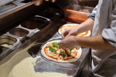 Erkek aşçı elleri pizzacı mutfağında pizza yapıyor.