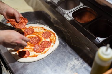 Erkek aşçı elleri pizzacı mutfağında pizza yapıyor.