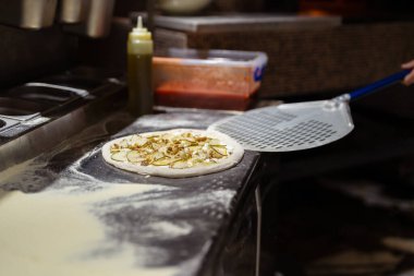 Erkek aşçı elleri pizzacı mutfağında pizza yapıyor.