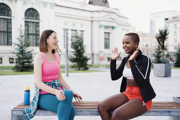 Cheerful Smiling Friends Sportswear Sitting Bench City Dicussing Park Multiethnic — Stock Photo, Image