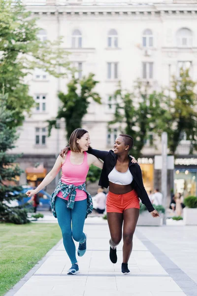 Amigos Sorridentes Alegres Sportswear Correndo Cidade Dicussing Mulheres Multiétnicas Fazendo — Fotografia de Stock