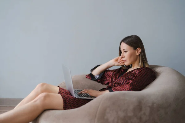 Жінка Шовковому Халаті Використовуючи Ноутбук Вдома Розслабляється Сидячи Мішку — стокове фото