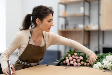 Çiçeklerle çalışan çiçekçi beste yapıyor.