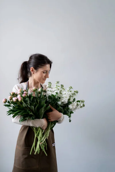 Kobieta Kwiaciarnia Embracing Kilka Białych Różowych Kwiatów Białym Tle Wewnątrz — Zdjęcie stockowe