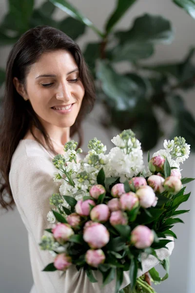 一个积极的女人拿着一束鲜花在她的办公室里 生日礼物微笑 — 图库照片