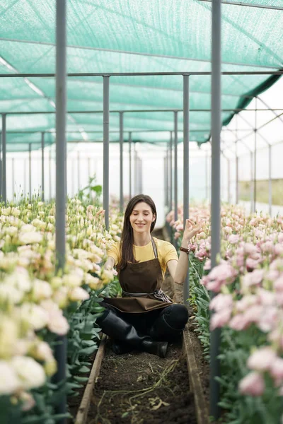Pretty Women Relaxing Flowers While Sitting Meditation Pose Green House — Stock fotografie