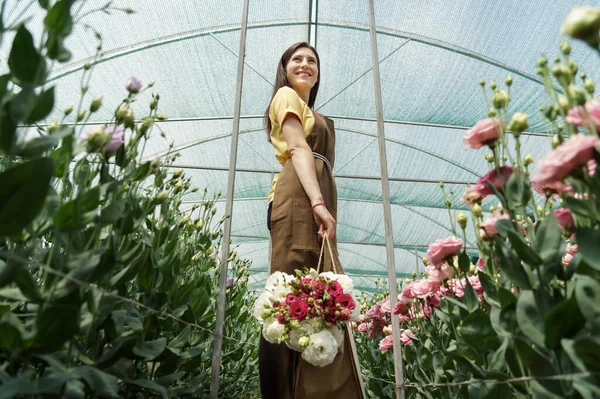 Жінка Флорист Ходить Серед Квітів Зеленому Будинку Кошиком Свіжим Букетом — стокове фото