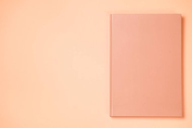 Leather notebook cover on a paper orange background, notepad mock up, top view shot