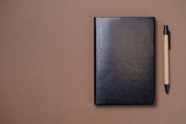 Kağıt kahverengi arka planda siyah deri defter, not defteri maket yap, üst görüntü çekimi
