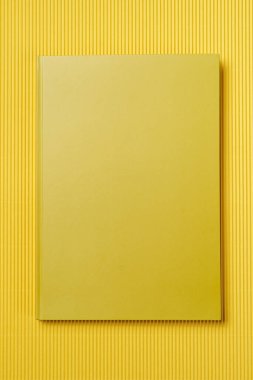 Kağıt sarısı zemin üzerinde sarı deri defter, not defteri maket yap, üst görünüm çekimi