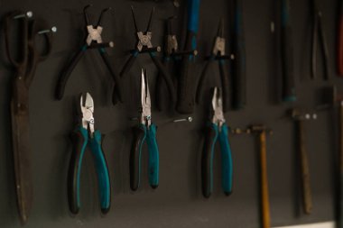 Atölye sahnesi. Atölyede duvarda asılı duran aletler, eski tarz garaj eşyaları.