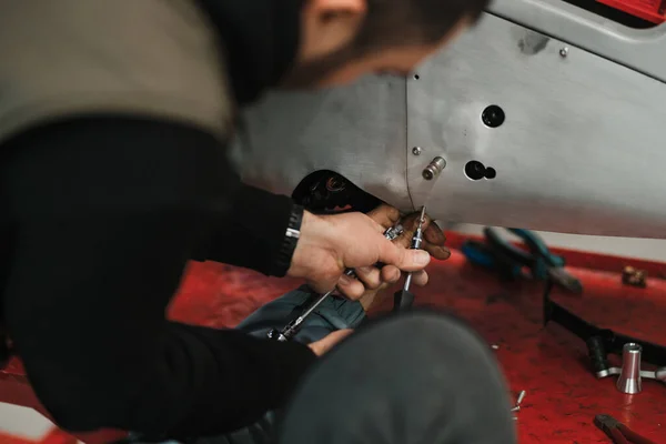 Repairman repair motorcycle, maintenance in garage. Mechanic fixing bike in a modern shop