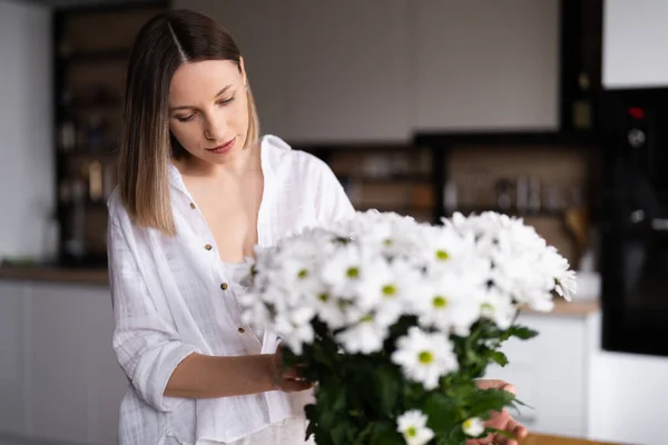 Счастливая Радостная Молодая Женщина Белом Устраивает Белые Цветы Дома Кухне — стоковое фото