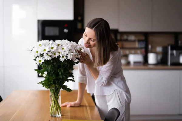 Щаслива Радісна Молода Жінка Білому Організовує Білі Квіти Вдома Кухні — стокове фото