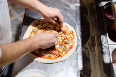 Pizza yapma süreci. Erkek aşçı elleri pizzacı mutfağında otantik pizza yapıyor..