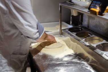 Pizza yapma süreci. Erkek aşçı elleri pizzacı mutfağında otantik pizza yapıyor..