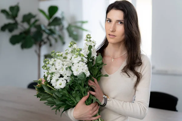 一个积极的女人拿着一束鲜花在她的办公室里 生日礼物微笑 — 图库照片