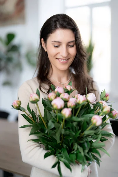 一个积极的女人拿着一束鲜花在她的办公室里 生日礼物微笑 — 图库照片