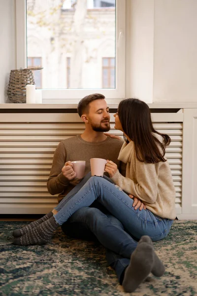 一对浪漫的夫妇在家里 一位迷人的年轻女子和一位英俊的男子一边手握一杯茶一边享受着在一起度过的时光 — 图库照片