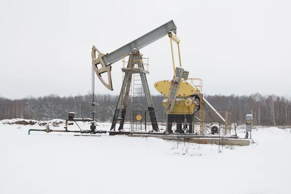 Oil pump works on winter forest background — Stock Photo, Image