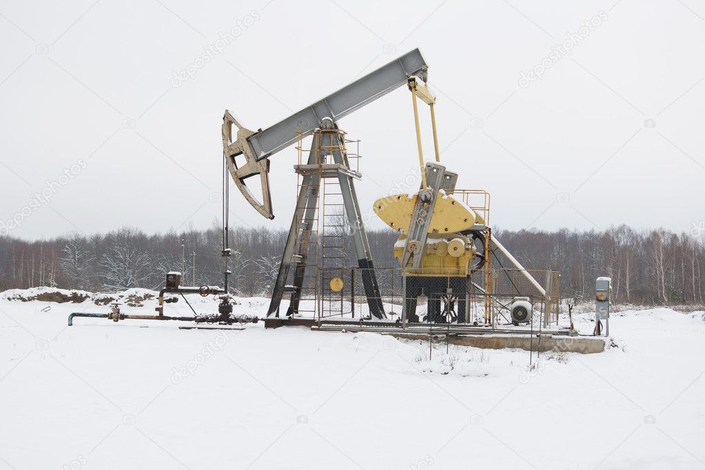 oil pump works on winter forest background