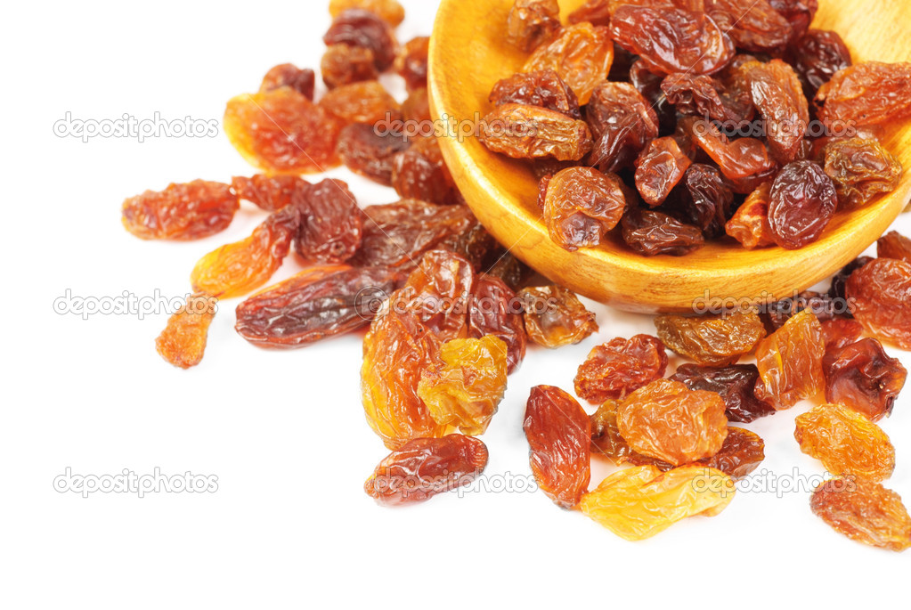 raisins and wooden spoon close- up isolated on white background