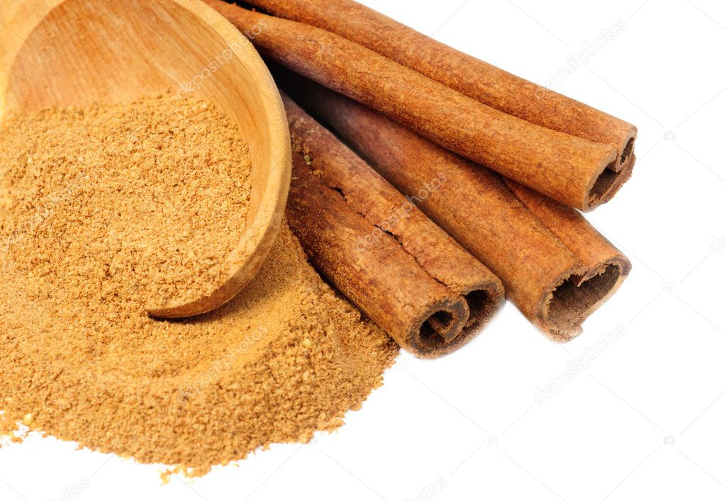 Cinnamon - sticks and powder and wooden spoon isolated on white