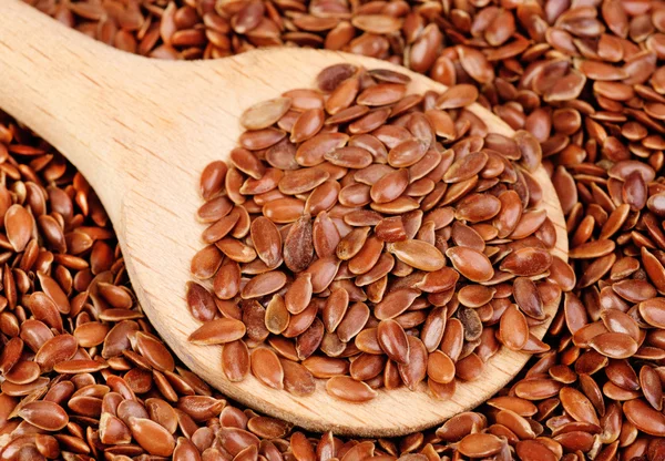 Close up of flax seeds and wooden spoon food background — Stock Photo, Image