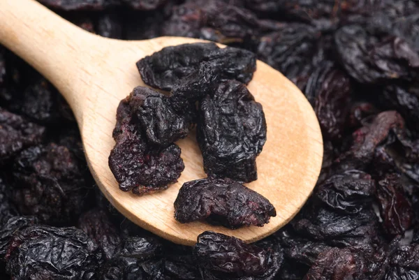 Raisins secs et cuillère en bois fermer- fond alimentaire — Photo