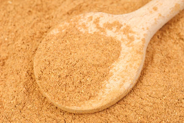 Cinnamon powder and wooden spoon as nature food background — Stock Photo, Image