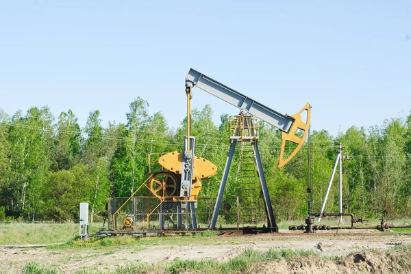 Oil pump works on spring forest background — Stock Photo, Image