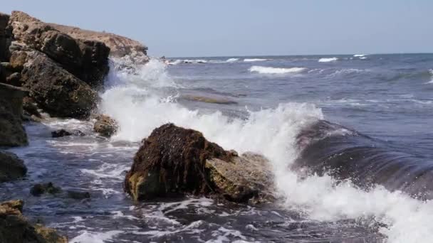 Ondas do mar quebram nas rochas costeiras. — Vídeo de Stock