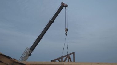 İnşaat işi. Özel bir evin çatısına ahşap bir kiriş kurulumu.