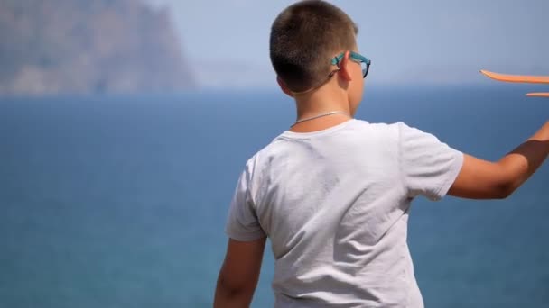 Menino com um avião de brinquedo em suas mãos no fundo do mar. — Vídeo de Stock